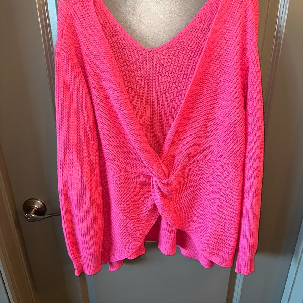 Bright pink sweater with a criss cross backless detail